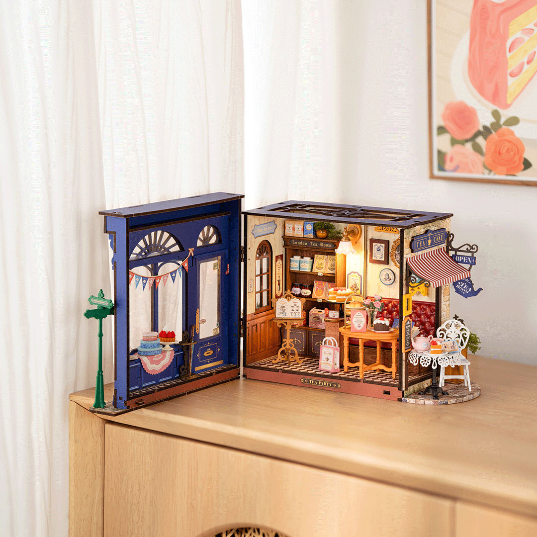 Open toy store model inside a wooden box on a table with a floral painting in the background.
